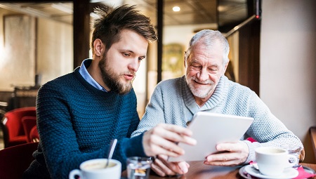 Two men using a tablet in a cafe